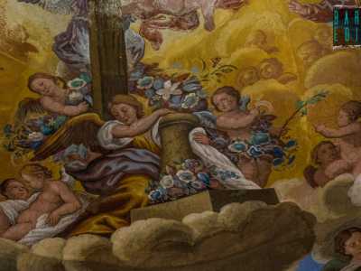 Altri putti alati volteggiano leggiadri tenendo tra le mani ghirlande e canestri di fiori...